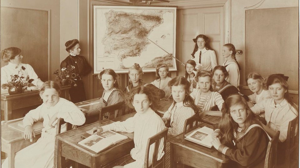 Foto av flickelever i klassrum tidigt 1900-tal.