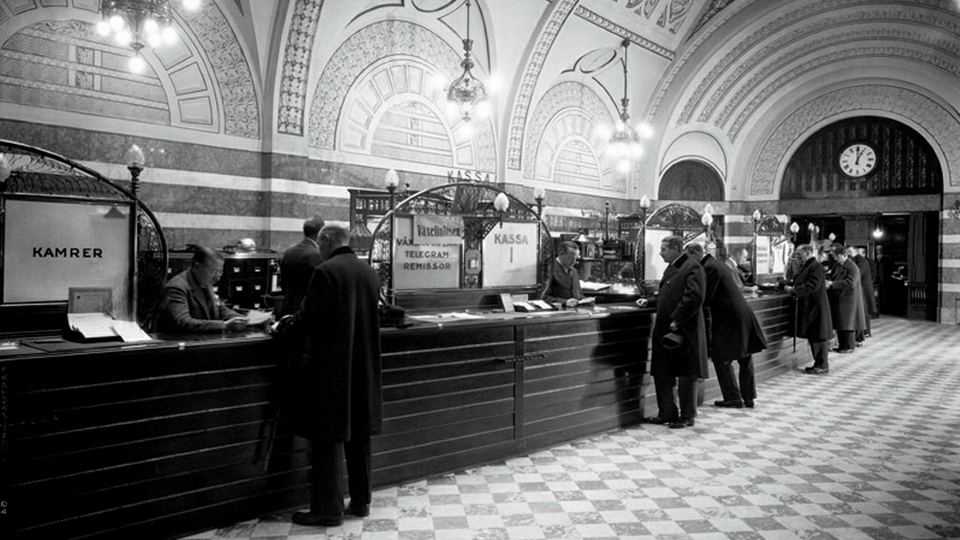 Personer i en banklokal. Foto.