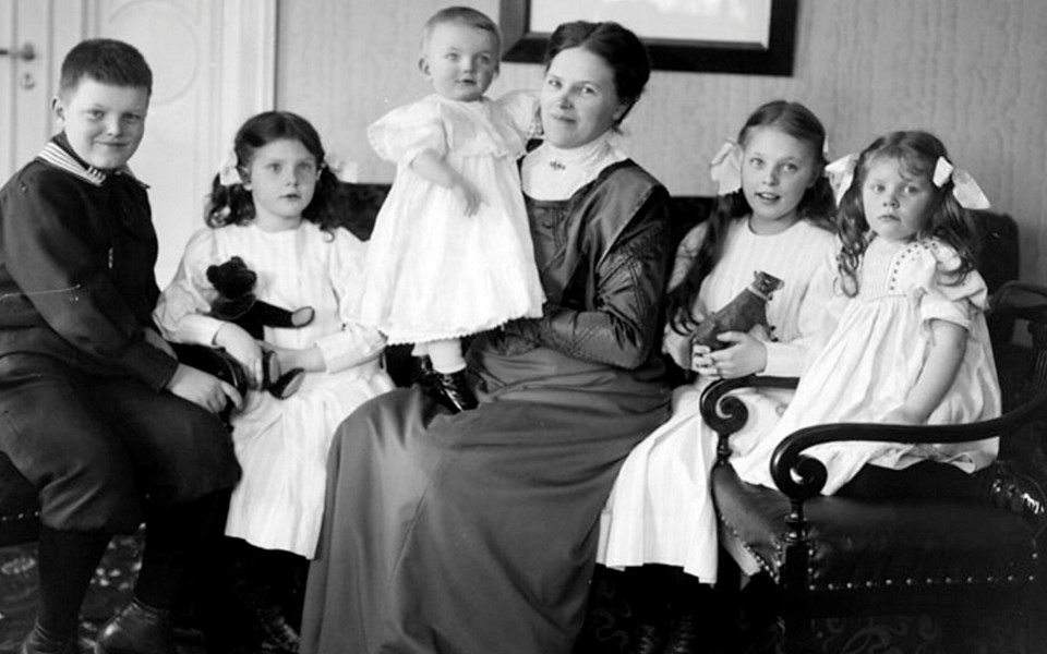 Fotografi av familj med mor och barn som sitter.