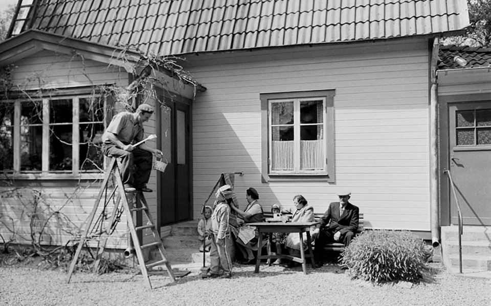 En familj sitter ute i sin trädgård.