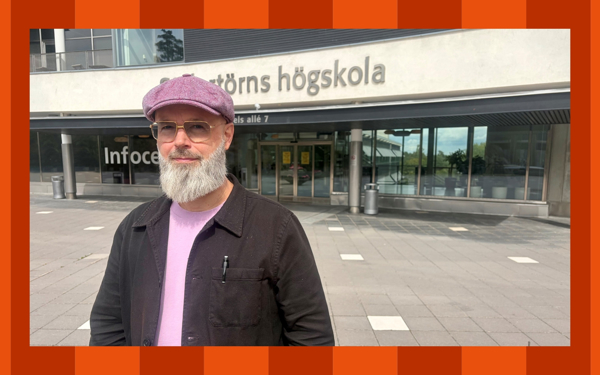 En man framför en skolbyggnad. Foto.